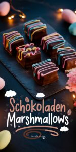 Selbstgemachte Schokoladen-Marshmallows mit Osterdekor auf schwarzem Schieferbrett – dunkle Kakao-Marshmallows mit bunten Zuckerglasurmustern und Glitzer